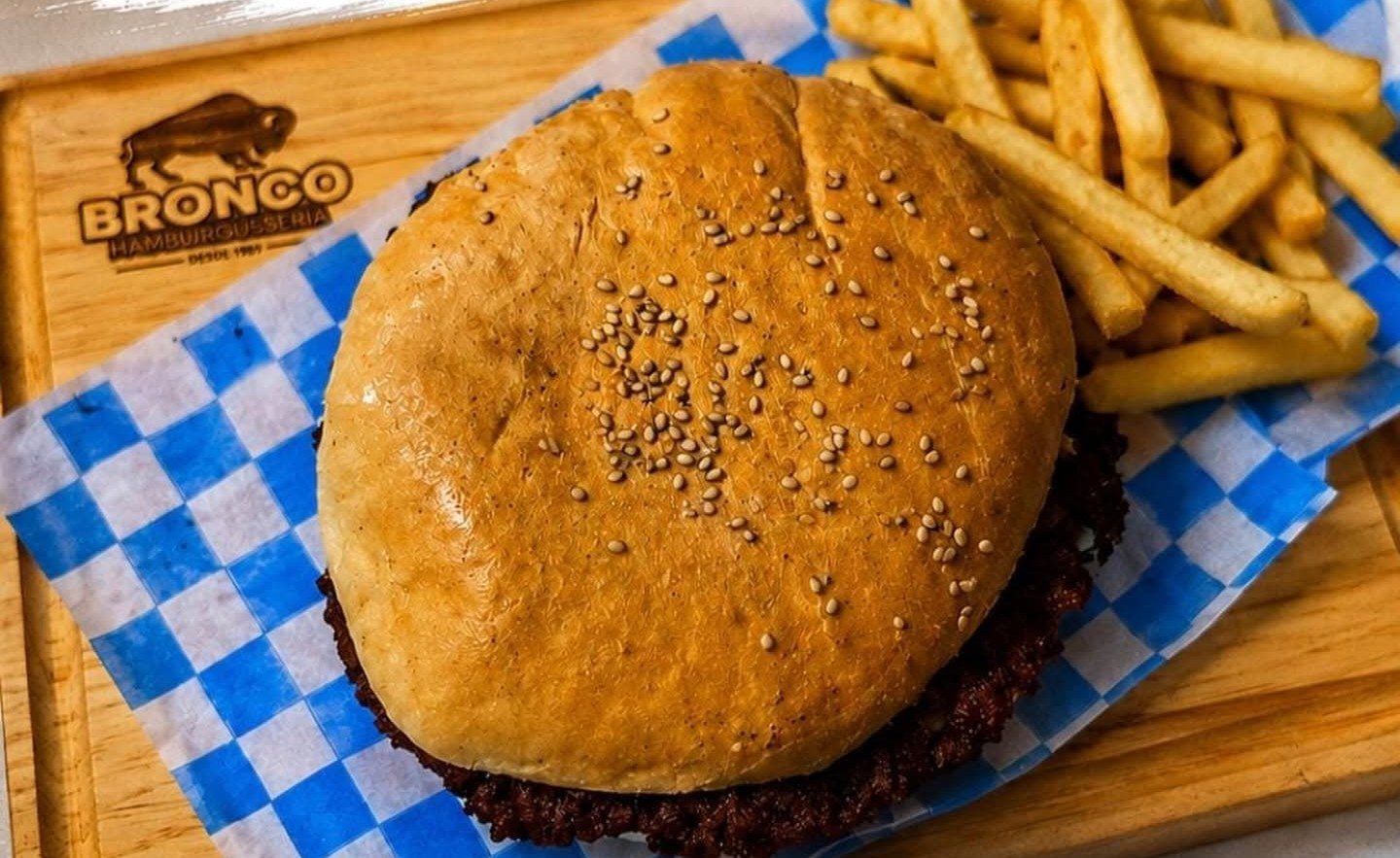 Hamburguesa Bronco con papas a la francesa sobre tabla de madera